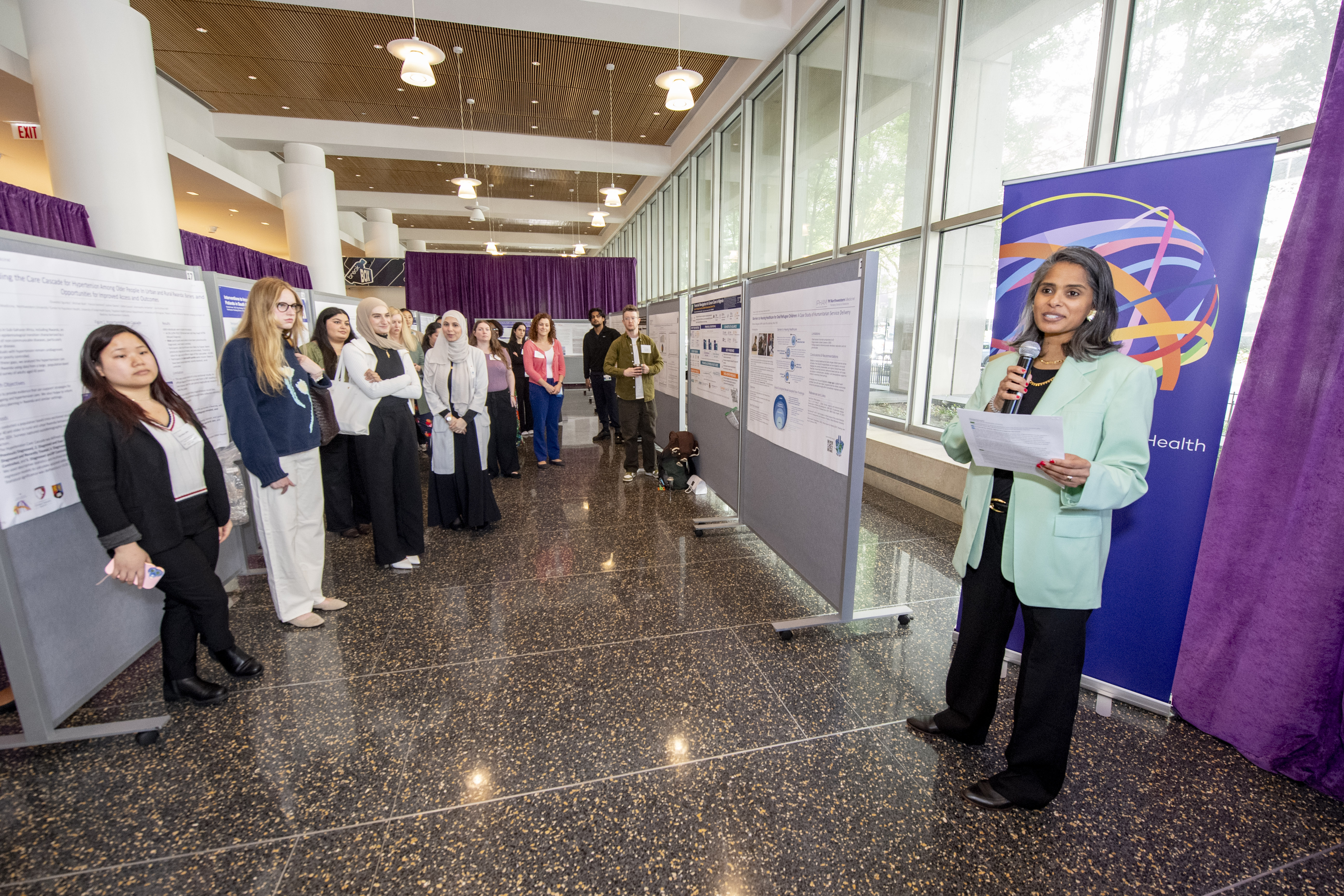 Attendees listen to a presentation in the Ryan Family Atrium