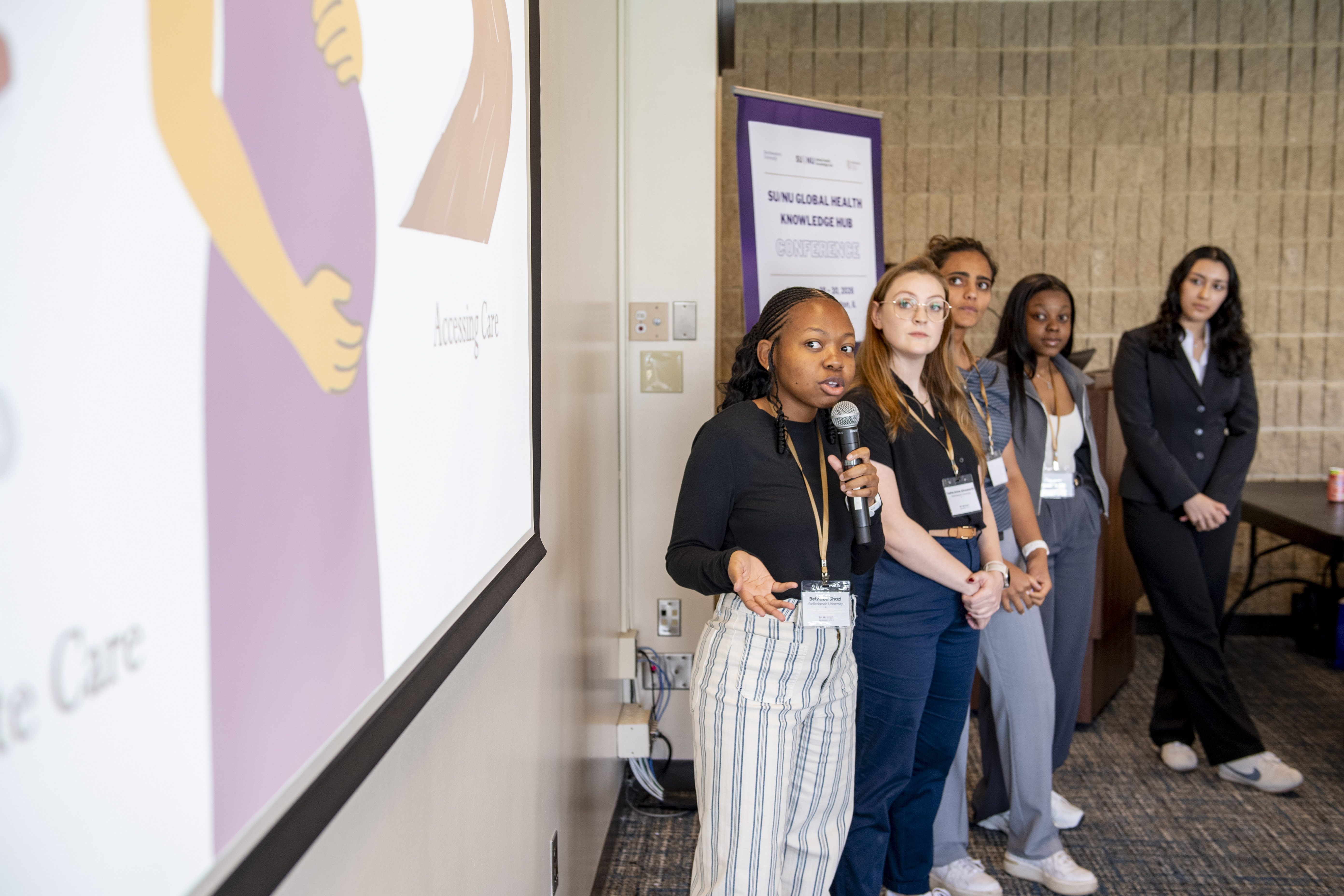 A team presents their work in front of a screen