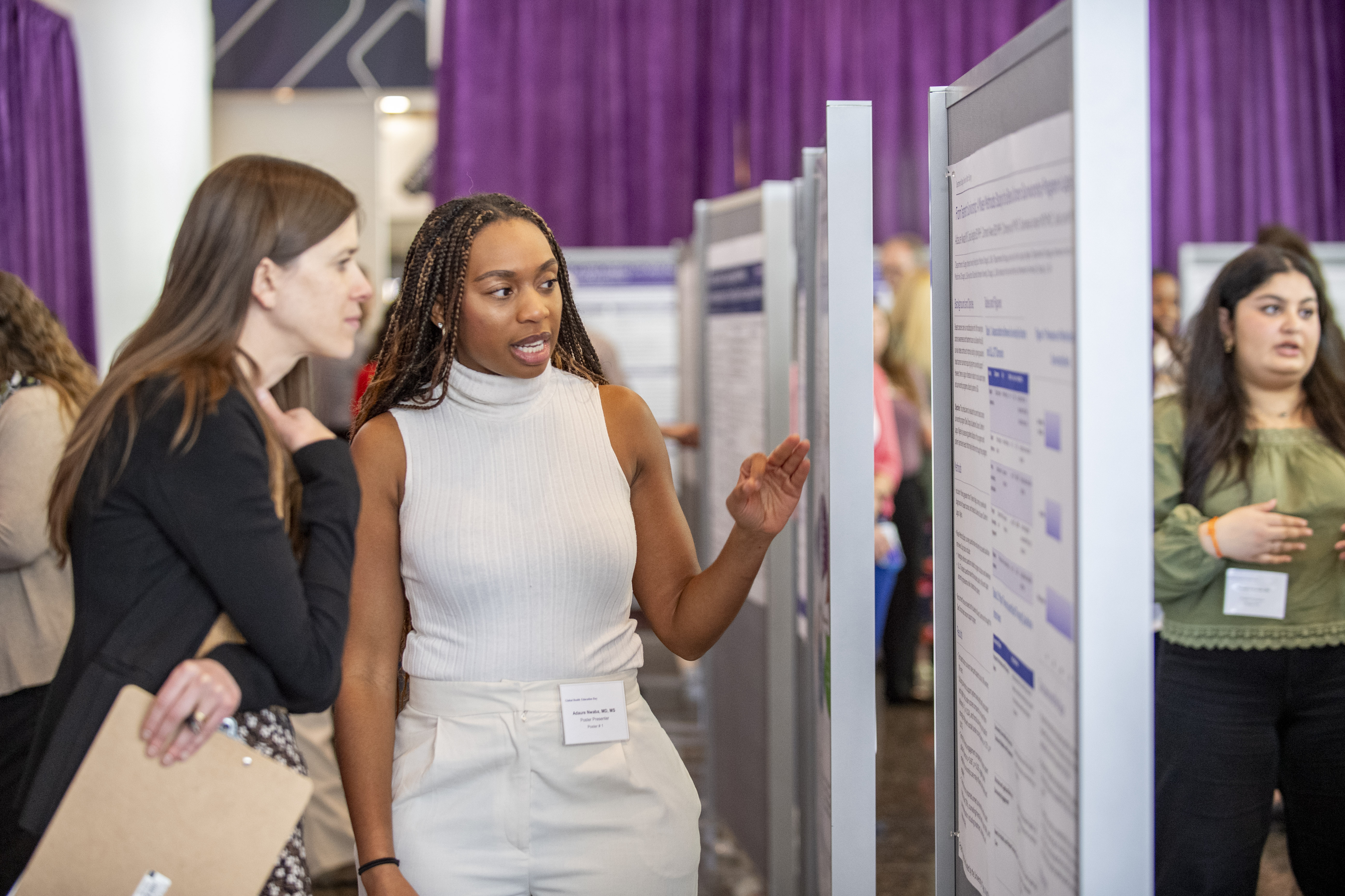 poster presenter shares their poster with an attendee