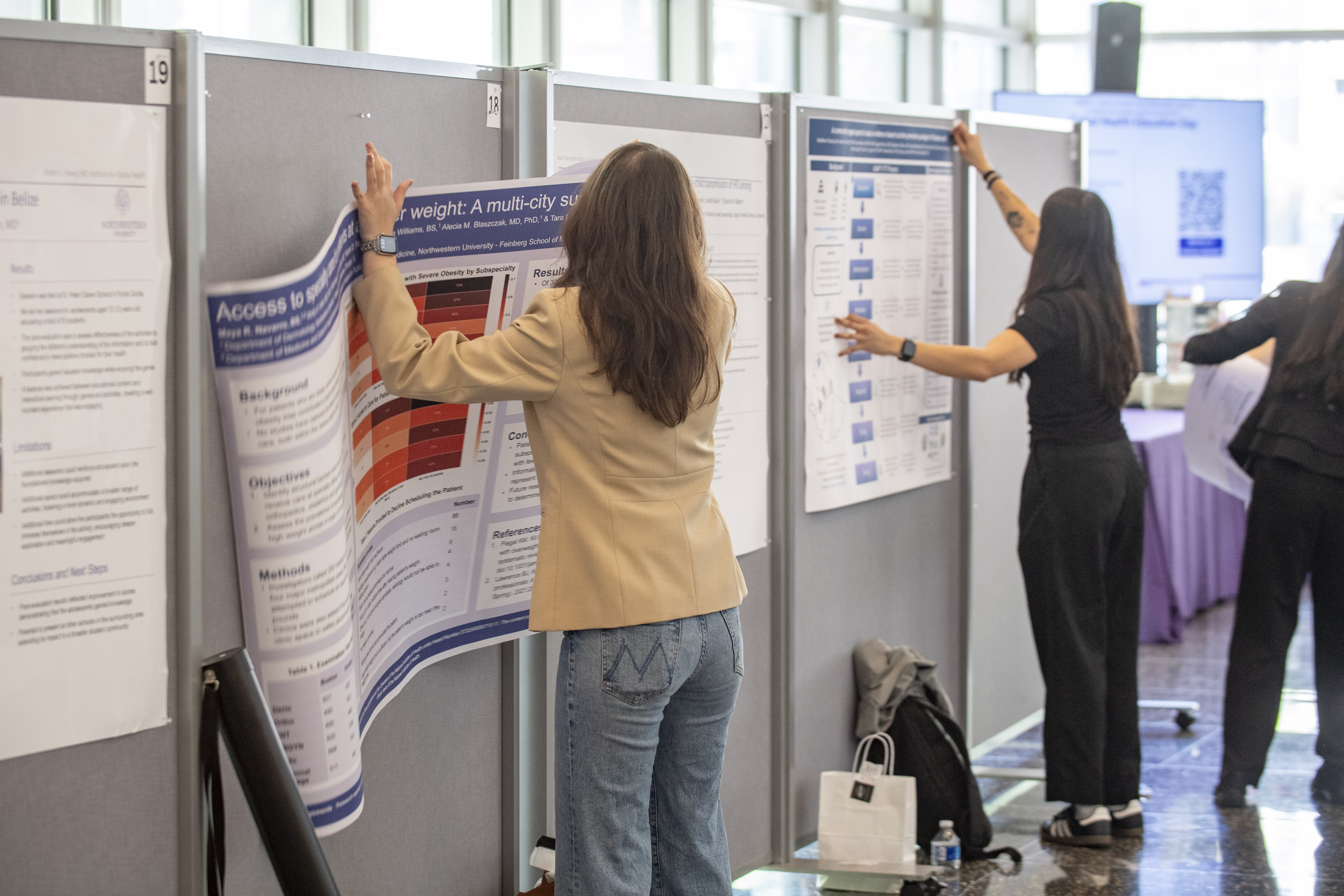Poster presenters hang up their posters