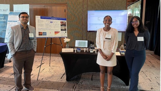 Team standing in front of a poster presentation
