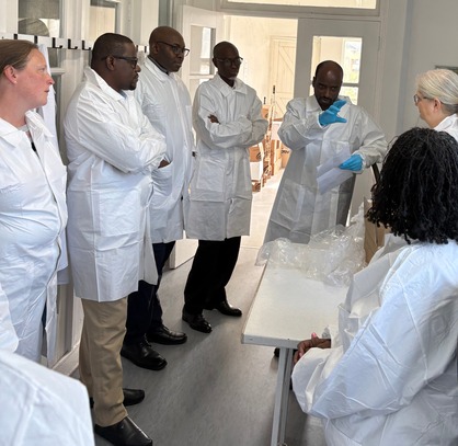 group standing in lab while wearing white lab coats