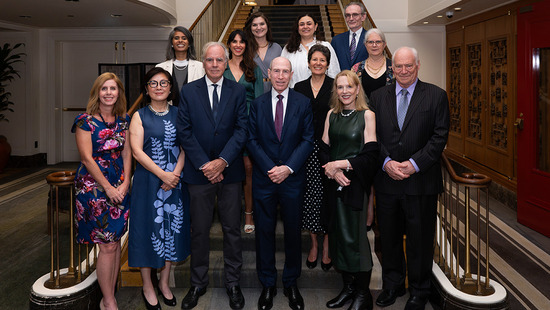 IGH leadership standing on a large staircase