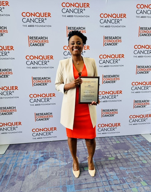 Juliet Lumati standing with her plaque