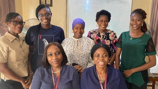 Seven women in Nigeria smiling for a photo
