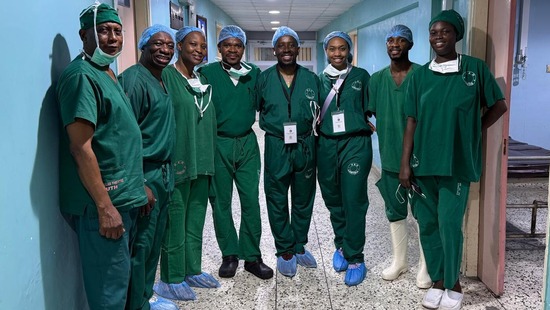 Surgeons in dark green scrubs standing in a hallway