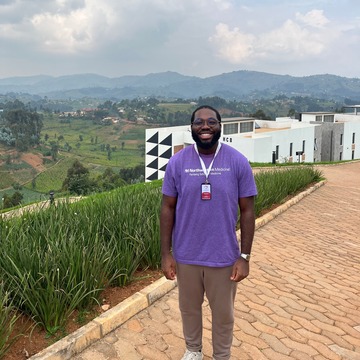 Tobi Ogunbiyi standing on Rwanda hillside