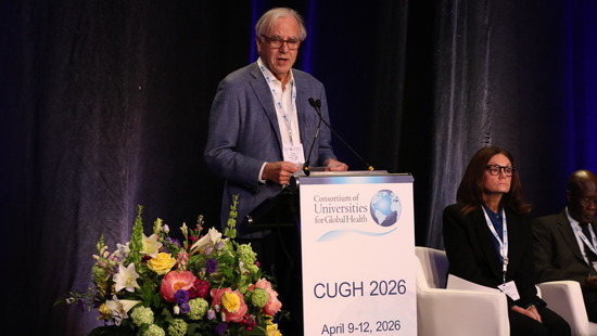 Rob Murphy standing at a podium accepting an award at the CUGH conference